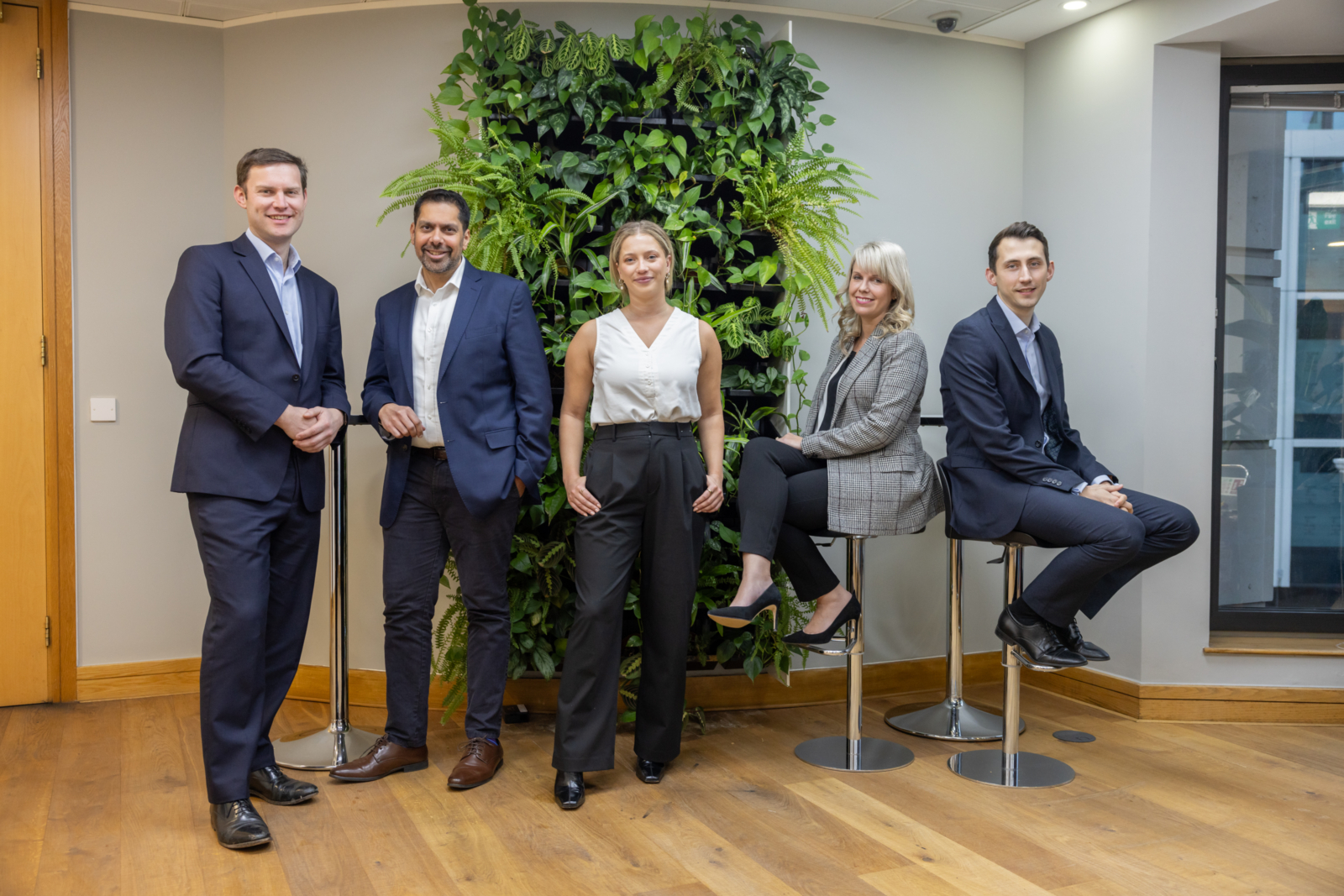 5 people in work attire facing camera and smiling