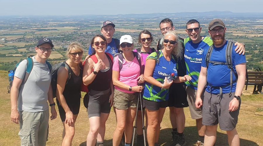 Group of people, happy at the end of climbing a hill