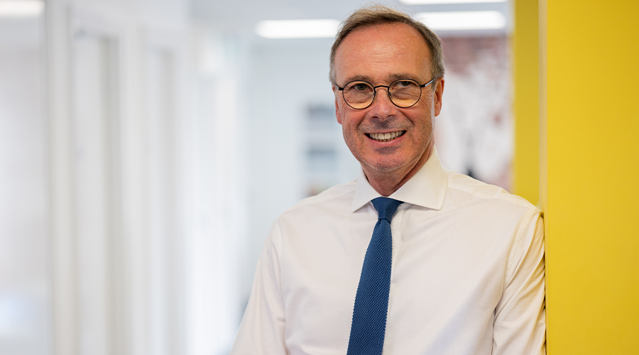 Lawyer standing in a hallway smiling at the camara