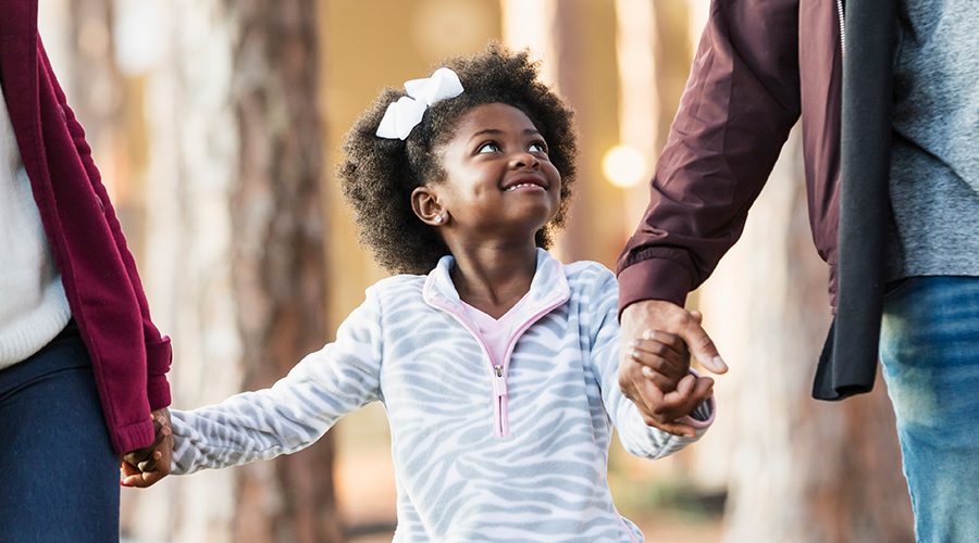 Little girl holding her parents hands