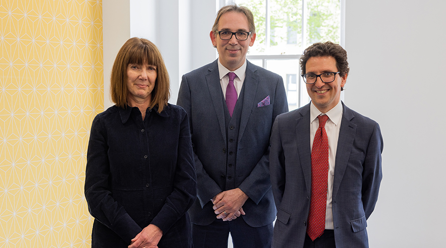 Group of three lawyers standing in front of the camera, smiling