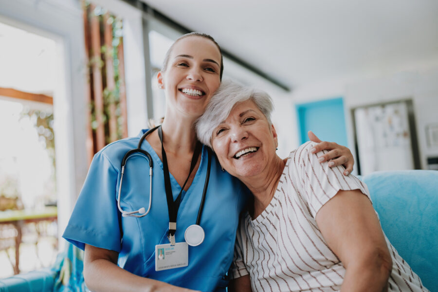 Home care healthcare professional hugging senior patient