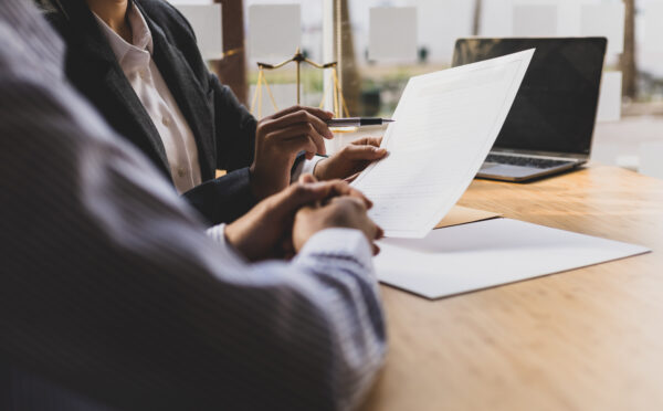 Female and male lawyer sitting at a desk, looking over a contract