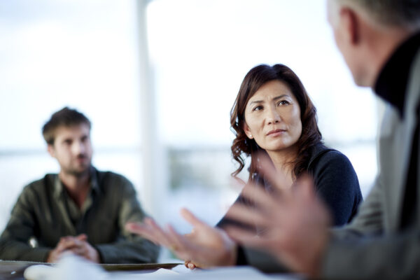 Three people discussing a at a table