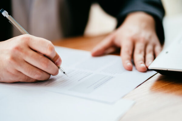 Businessman filling official document, signing contract.