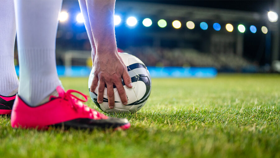 A player preparing a football in a stadium