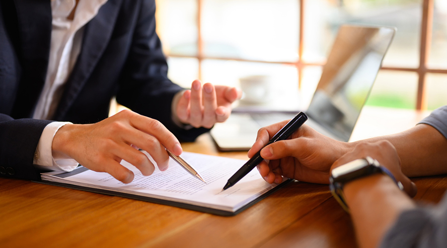 Person signing a contract with a pen