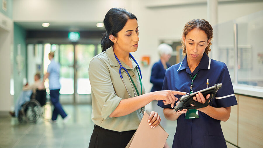 Two female health carers looking at papers, in a healthcare setting