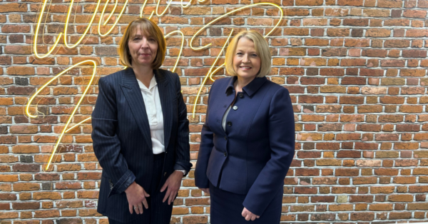 Two female partners standing in front of the camera, smiling