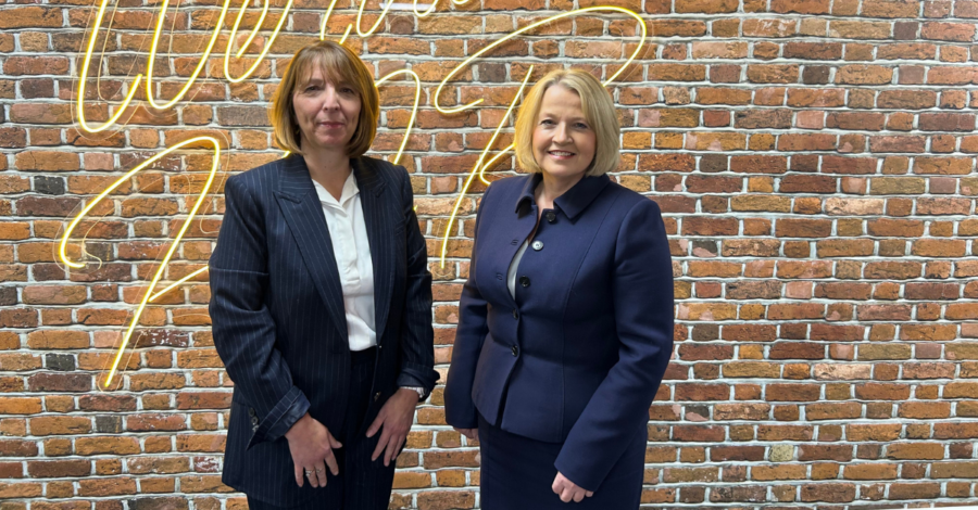 Two female partners standing in front of the camera, smiling