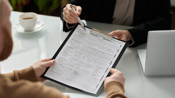 two people looking at a chart on a paper