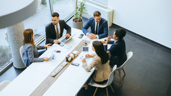 Employees sitting around the desk at the office